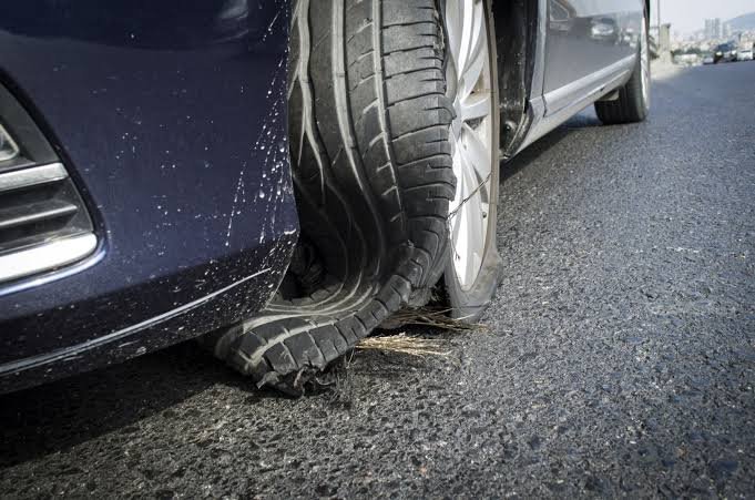 Blown-out tyre on a car at the roadside