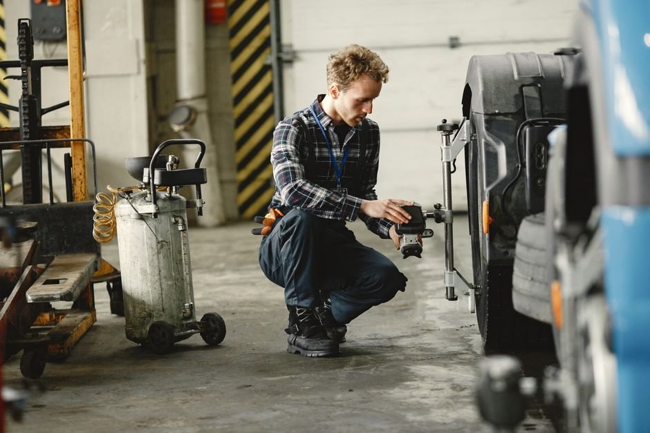 Mobile tyre fitter working on a car wheel from a van